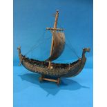 A cast metal model of a Viking long boat, on stand