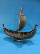 A cast metal model of a Viking long boat, on stand