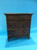 A miniature oak chest of drawers