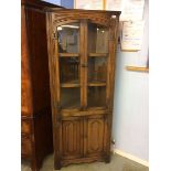 An oak linenfold corner cabinet