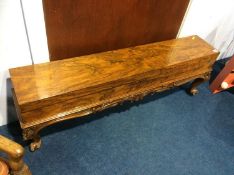 A narrow walnut box, supported on carved scrolling legs