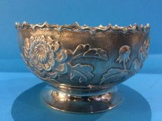 An Oriental white metal bowl decorated with chrysanthemums, marks to base , 18.7oz