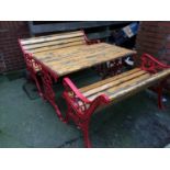 A slatted garden table with metalwork ends and a pair of benches