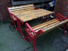 A slatted garden table with metalwork ends and a pair of benches