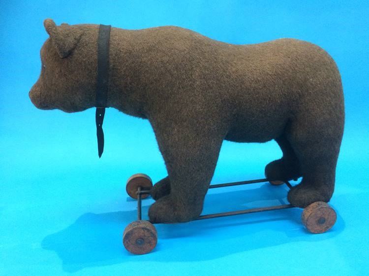 An early 20th century pull-along 'Growling' bear (probably Steiff), straw filled, standing on a cast