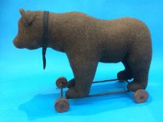 An early 20th century pull-along 'Growling' bear (probably Steiff), straw filled, standing on a cast