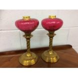 A pair of part oil lamps with cranberry reservoirs