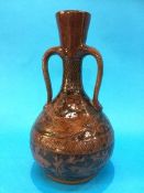 A C.H. Brannam ware pottery two handled vase, on a