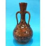 A C.H. Brannam ware pottery two handled vase, on a