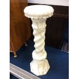 An Alabaster pedestal with circular top and barley twist column