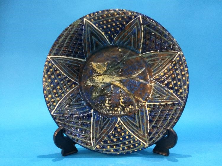 An Art and Crafts style pottery wall charger, decorated with fish, 28cm diameter