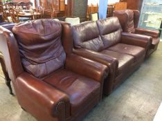 A brown leather three piece suite