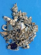A charm bracelet with various silver charms etc.