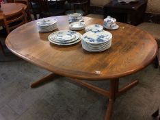 A large teak extending dining table