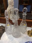 A glass hurricane lamp and three decanters