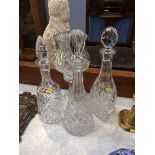 A glass hurricane lamp and three decanters