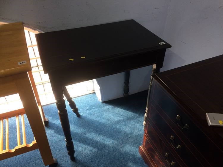 An ebonised side table with rising top