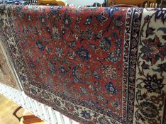 A Persian rug, the pink ground bearing all over naturalistic floral sprays in blue, ivory and green,