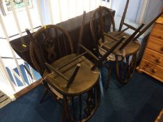 A narrow Ercol oak drop leaf table and four chairs