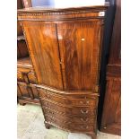 A reproduction mahogany serpentine cocktail cabinet with brushing slide, 69cm wide