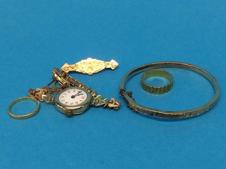 Two 18ct gold rings, 7.7gram, a 9ct brooch, 1.9gram, a ladies 9ct gold wristwatch and a yellow metal