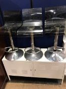 Three plaster and chrome bar stools and a two door metal cabinet