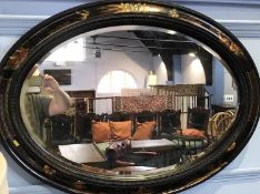 An Oriental lacquered standard lamp and oval mirror