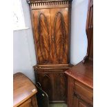 A reproduction mahogany corner cabinet