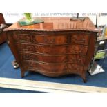 A reproduction mahogany Chapmans 'Siesta' serpentine chest of drawers, with tooled leather