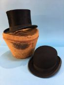 A bowler hat, a top hat and leather case