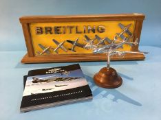 A Breitling advertising board, together with a Breitling plane paperweight and a catalogue