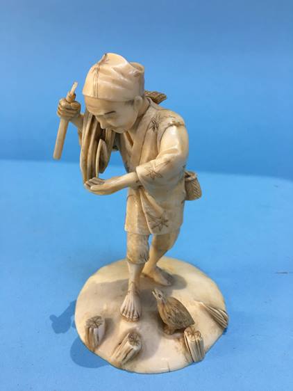 A 19th century ivory figure of a man gathering rice