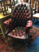 A burgundy Chesterfield button back swivel armchair