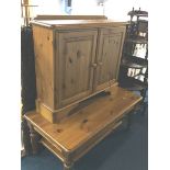 A pine two door cabinet and a coffee table