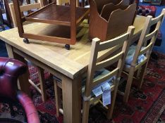 A modern oak extending dining table and four chairs