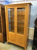 A light oak Chapmans Siesta glazed cabinet
