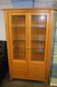 A light oak two door display cabinet