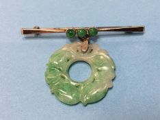 A 9ct brooch mounted with carved jade pendant