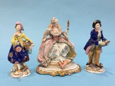 A pair of Continental porcelain figures of a gallant and lady and a Capo di Monte figure of a seated