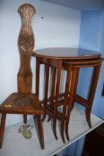 A carved chair and an oval nest of tables