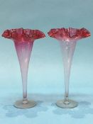 A pair of Victorian glass spill vases with flared cranberry coloured tops. 29cm high