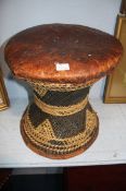 A pair of leather top circular stools with a wicker work box