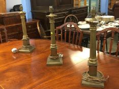 A set of three Corinthian column brass table lamps