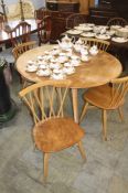 An Ercol Golden Dawn table and a set of four Ercol stick back chairs