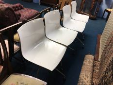 Set of four white and chrome swivel chairs