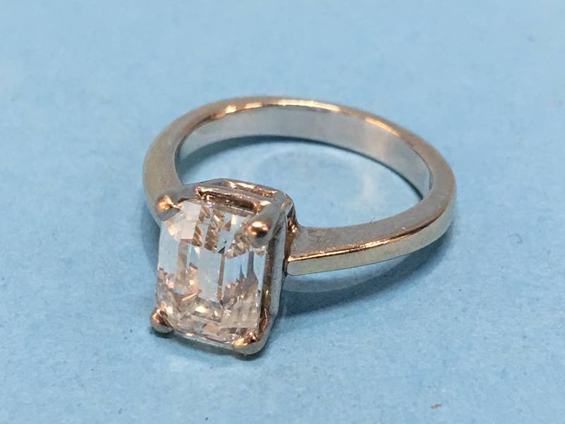 An 18ct white gold ring, set with a single emerald cut diamond, colour H/I, clarity SI2/I1,