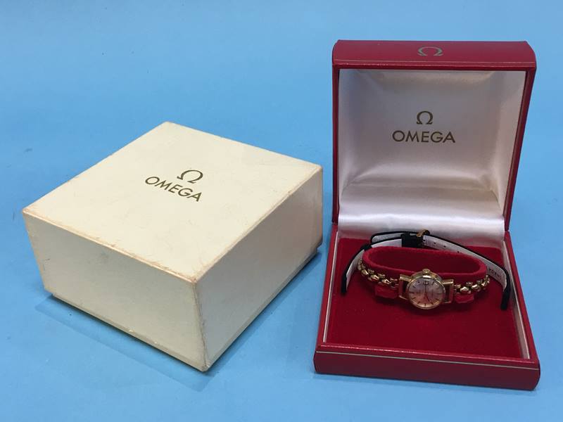 A ladies 9ct gold wristwatch, the dial signed Omega, Ladymatic, with boxes and paperwork, total