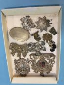A collection of various white metal crests, cap badges etc.