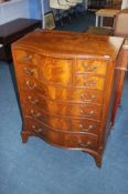 A good quality reproduction mahogany serpentine fronted chest of drawers, with central deep