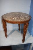 A circular table inlaid with Moorish motifs